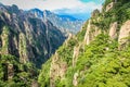 Stone is covered with scrubby pine trees looking in a valley far into the horizon in Huang Shan Ã©Â»âÃ¥Â±Â±, Yellow Mountains Royalty Free Stock Photo